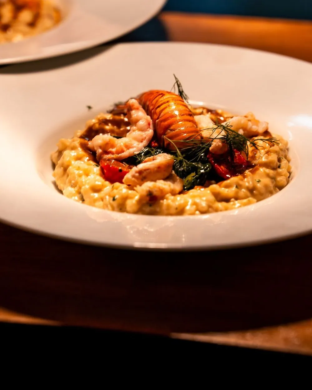 Un risotto garni de crevettes, dressé dans une assiette creuse